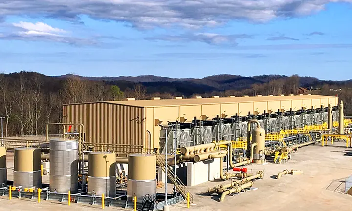 A finished compressor station with tanks, piping and a long equipment building